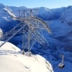 The Loen Skylift cable car ascending a steep mountain cliff overlooking the blue Nordfjord in Norway