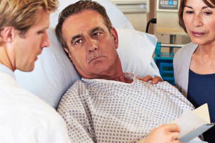 A doctor and a patient's wife engaging in a focused and respectful discussion at his bedside in a hospital